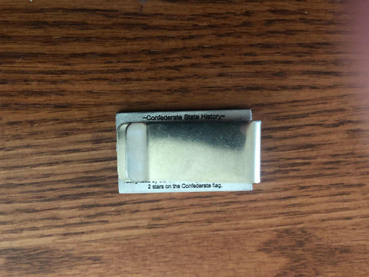 Old Mississippi State Flag Money Clip A silver metal money clip with printed text on its sides, resting on a brown wooden surface.