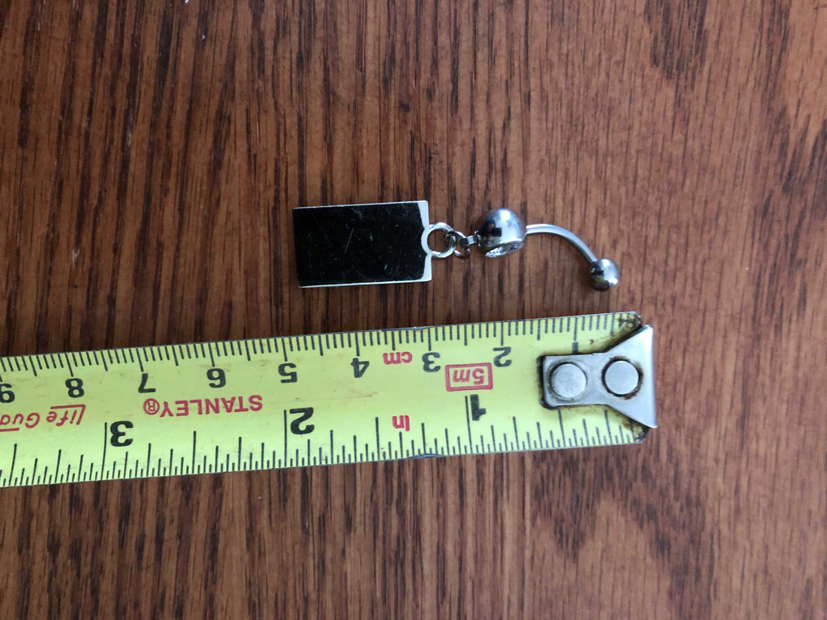 Camo Confederate Battle Flag Navel Belly Button Ring Body Jewelry next to a ruler to show size